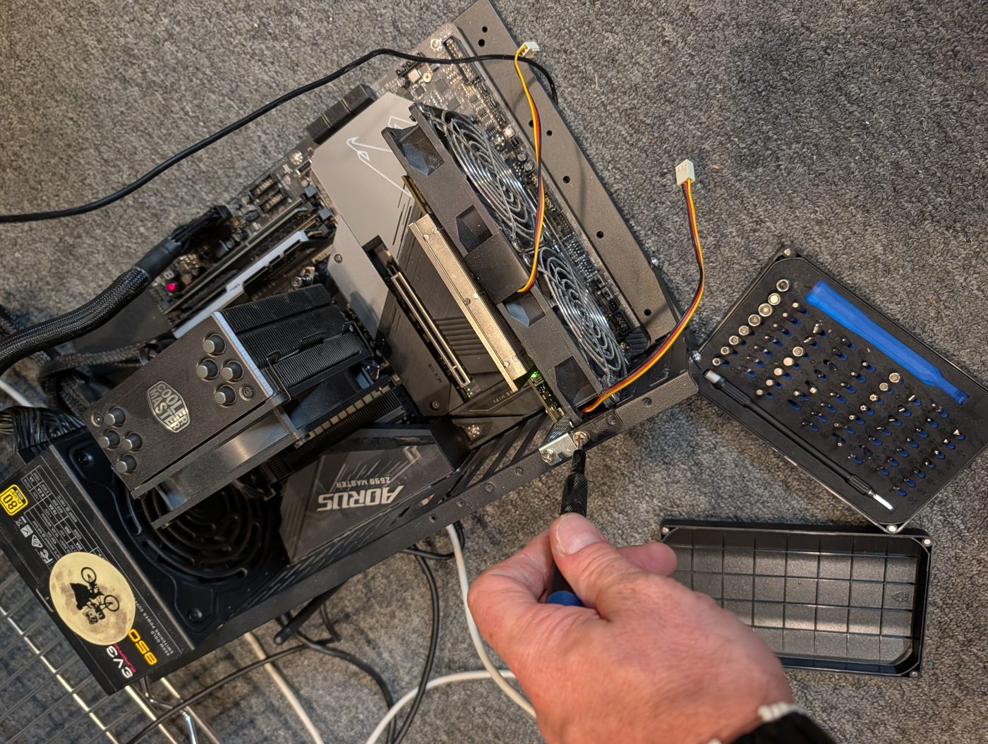 The two-fan bracket screwed into aifoundry2's frame beside the card, with its 3-pin fan cables loose.